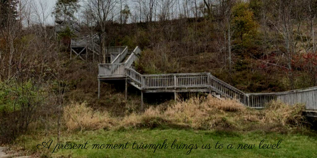 Wooden stairs leading up a bluff with a caption of 'A present moment triumph brings us to a new level