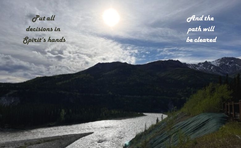Sun behind clouds over the Alaska mountain and river.