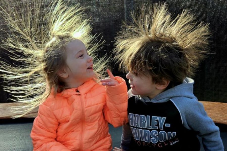 Twins with hair floating up due to static